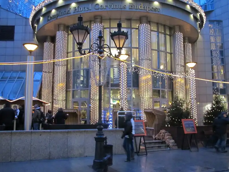 A Kempinski Hotel Corvinus Budapest kivilágított bejárata decemberben