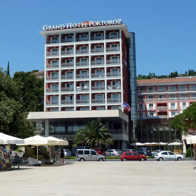 A Grand Hotel Portorož homlokzata az üveg liftaknával és az alacsonyabb szárnnyal