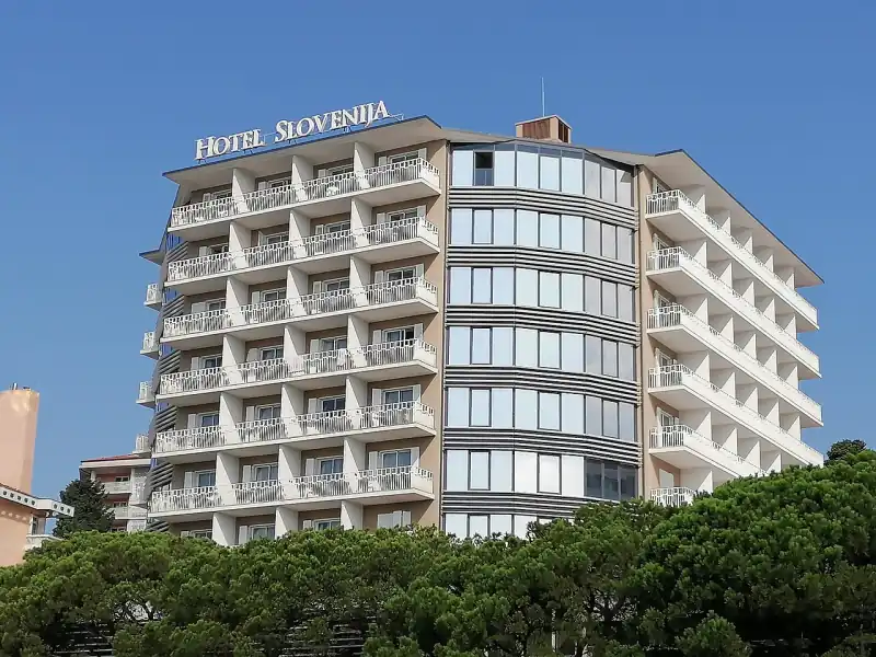 A Hotel Slovenija tornya a tetején a szálloda nevével, a fenyők fölött